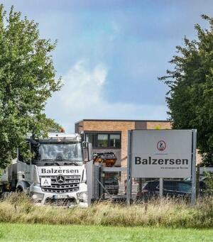 Ein LKW, Schild und Geb&auml;ude von der Deponie Balzersen